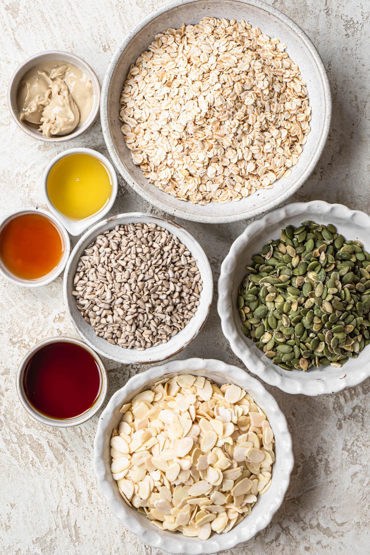 Ingredients for vanilla almond granola, laid out in individual bowls.
