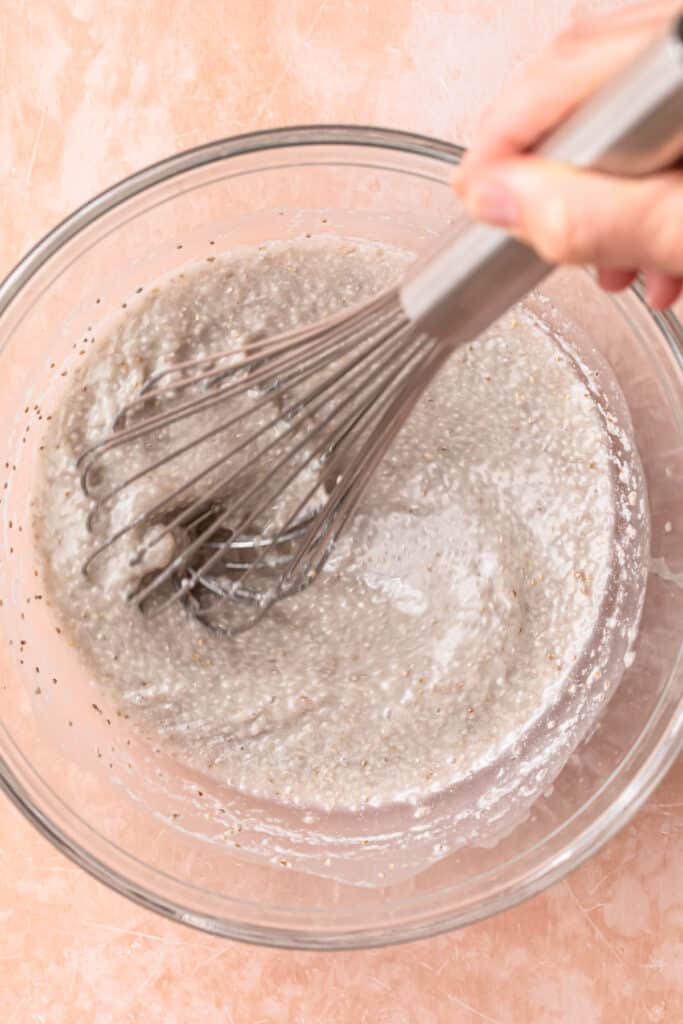 Coconut chia pudding mixture being whisked together in a mixing bowl.