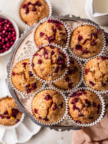 Top down photo of gluten free orange cranberry muffins on a silver platter.