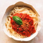 spaghetti, lentil bolognese and basil in bowl
