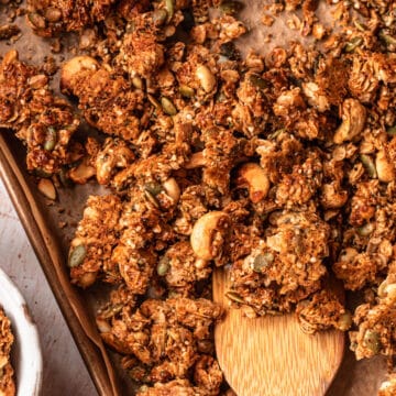 Golden brown cashew granola on a baking tray.