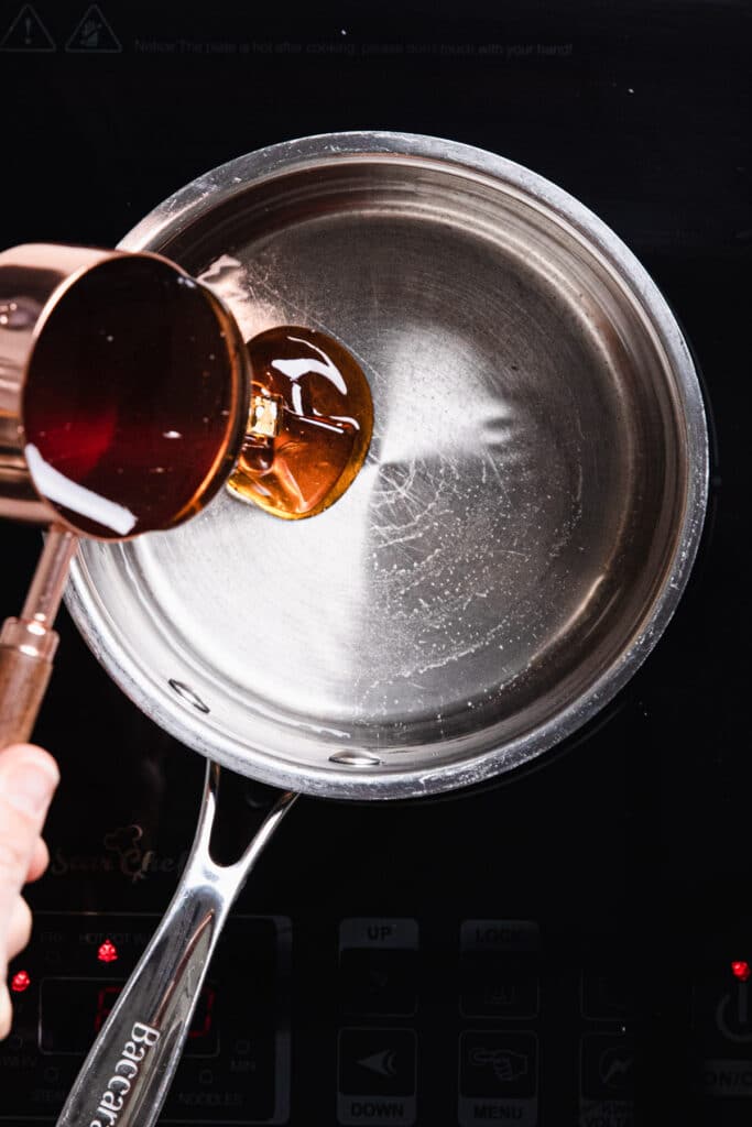 Pour honey into saucepan with water
