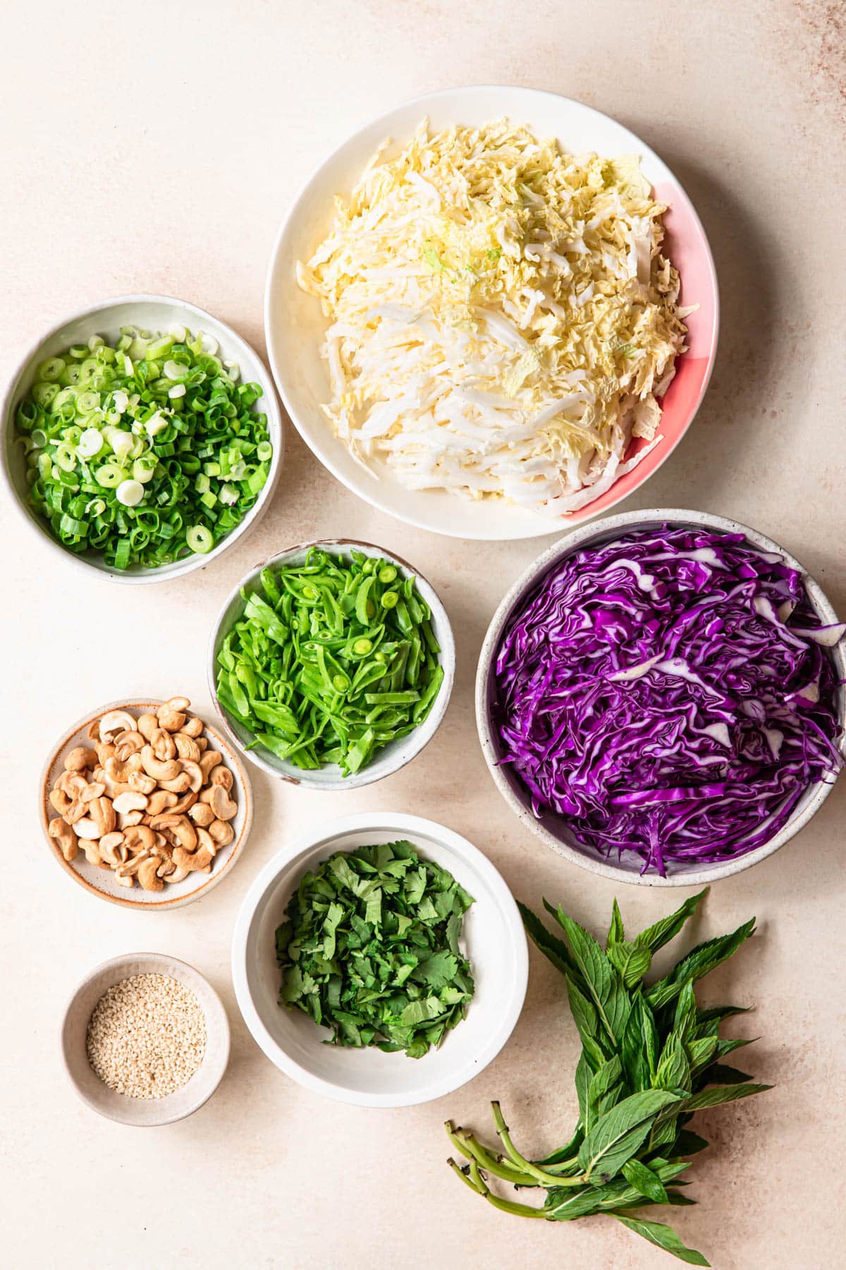 Ingredients for Asian coleslaw laid out in individual bowls.