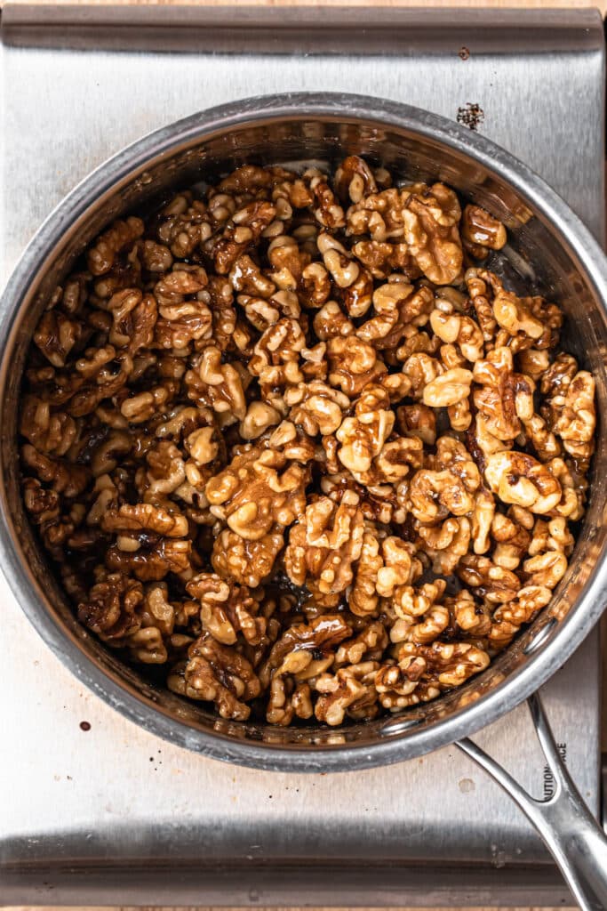 Walnuts added to warmed honey in a saucepan.