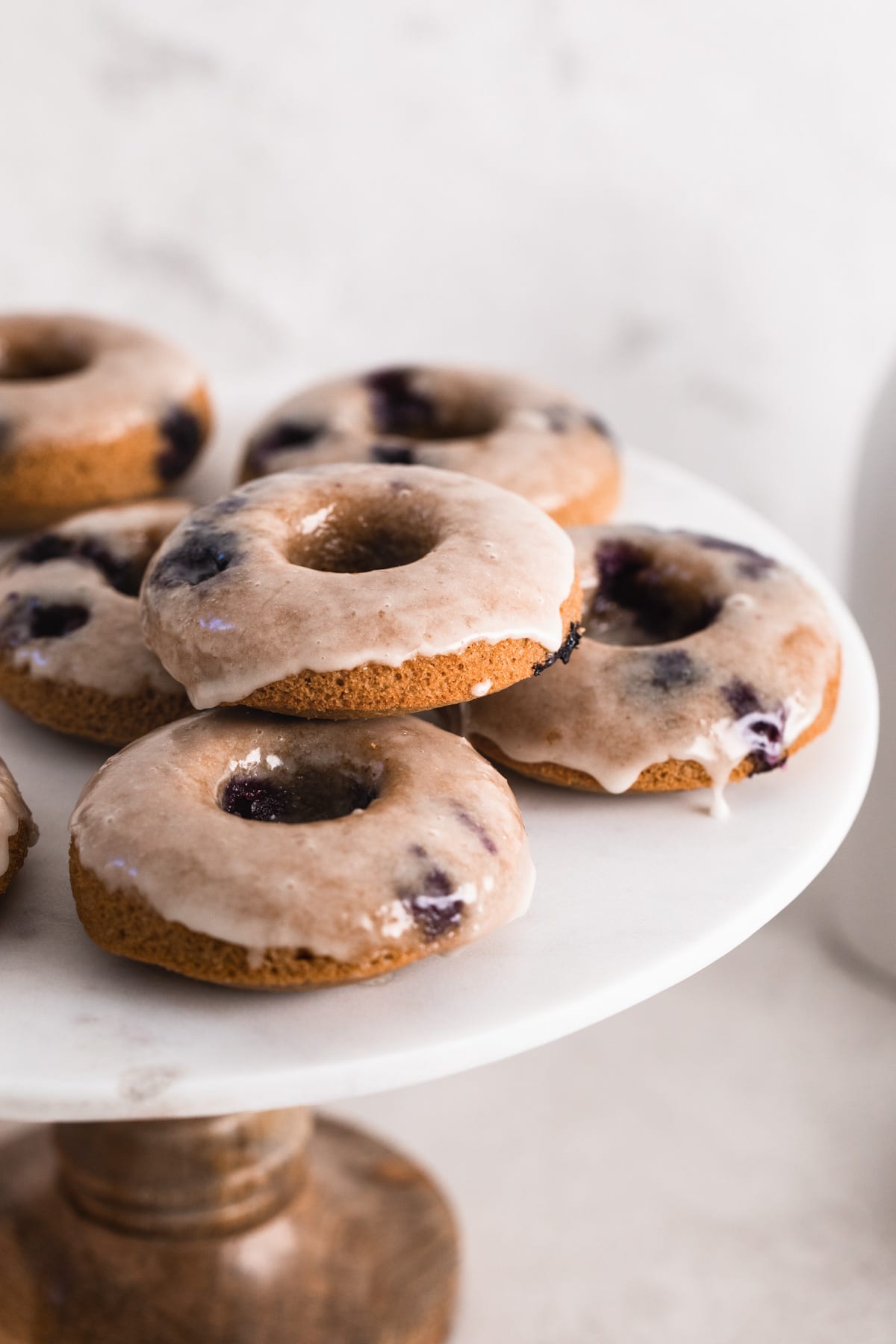 healthy baked blueberry donuts with lemon glaze on cake stand