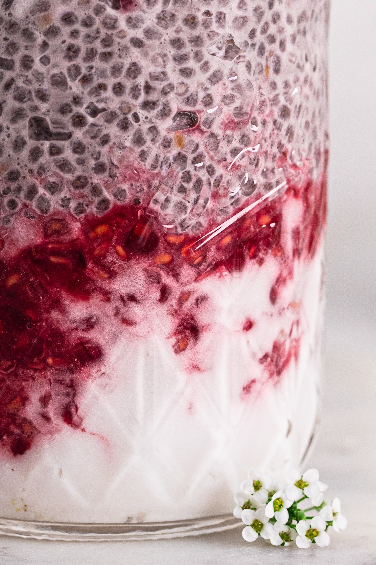 macro close up image of dairy free chia pudding layered with coconut yoghurt and berry puree