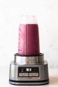 Spinach and berry smoothie in bullet blender, blended together.