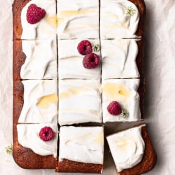 A paleo, raspberry and coconut cake topped with coconut yoghurt, honey and raspberries.