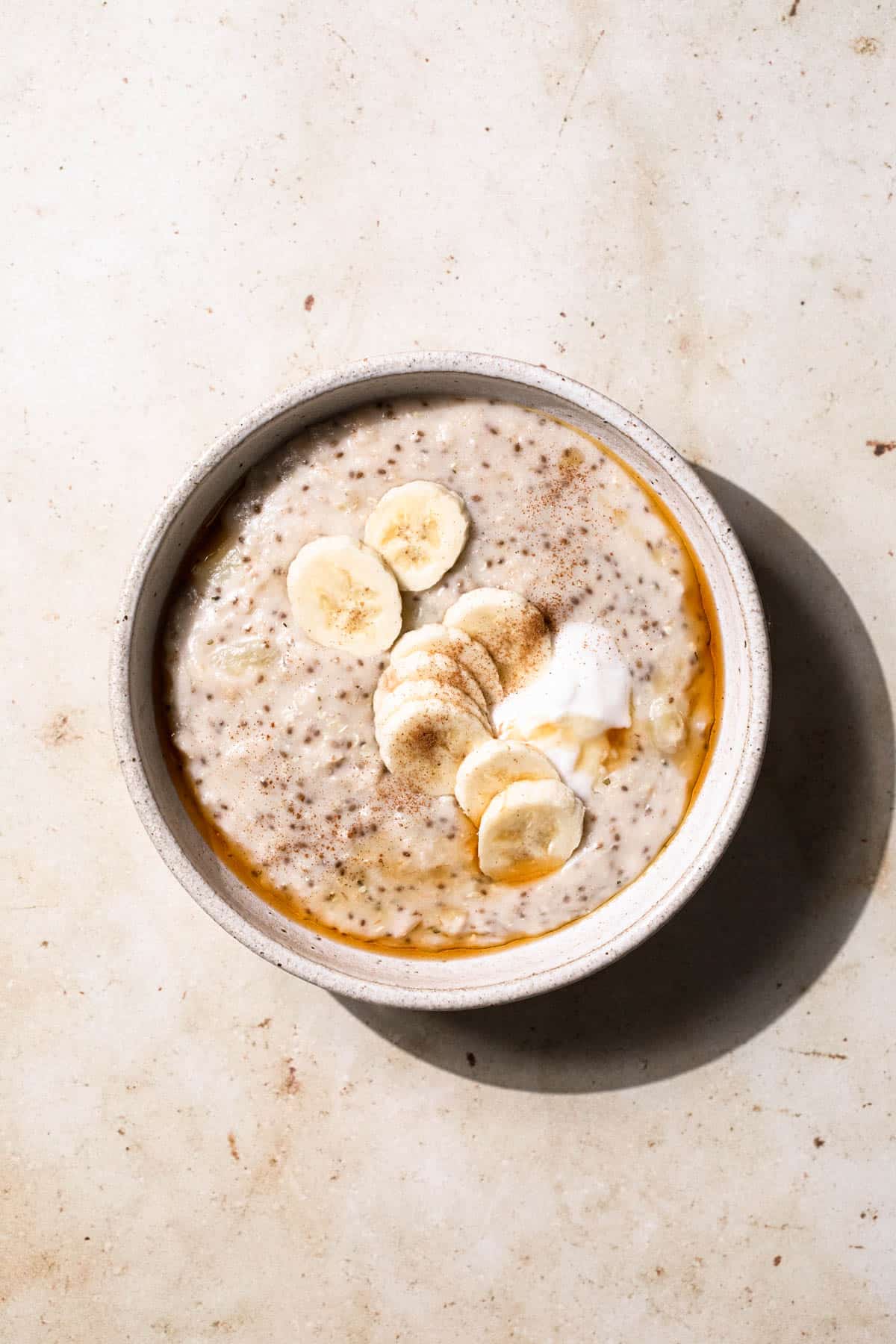 Porridge served with banana slices, coconut yoghurt, cinnamon and pure maple syrup.