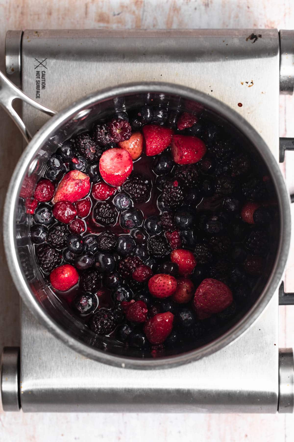 Frozen mixed berries in a saucepan.