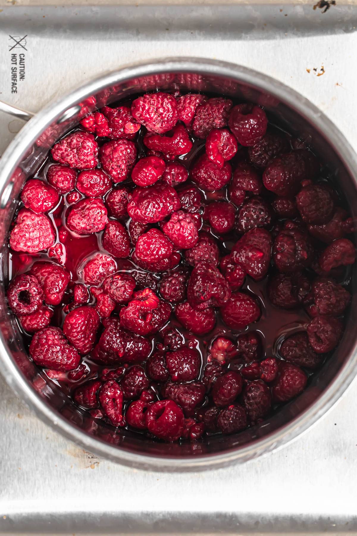 Ingredients for raspberry compote added to a saucepan.
