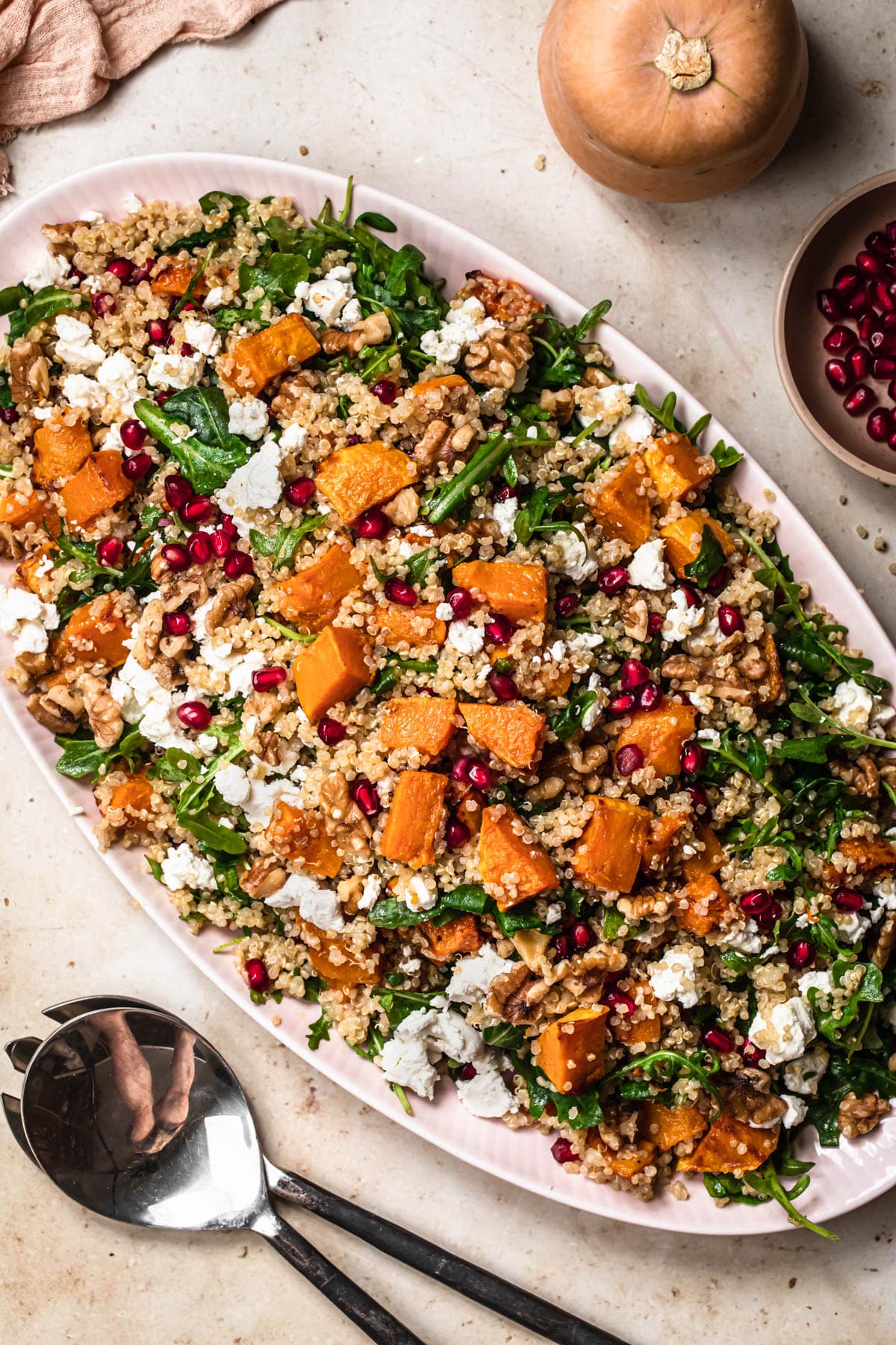 Butternut squash and quinoa salad on a serving platter, dressing with maple dijon dressing.