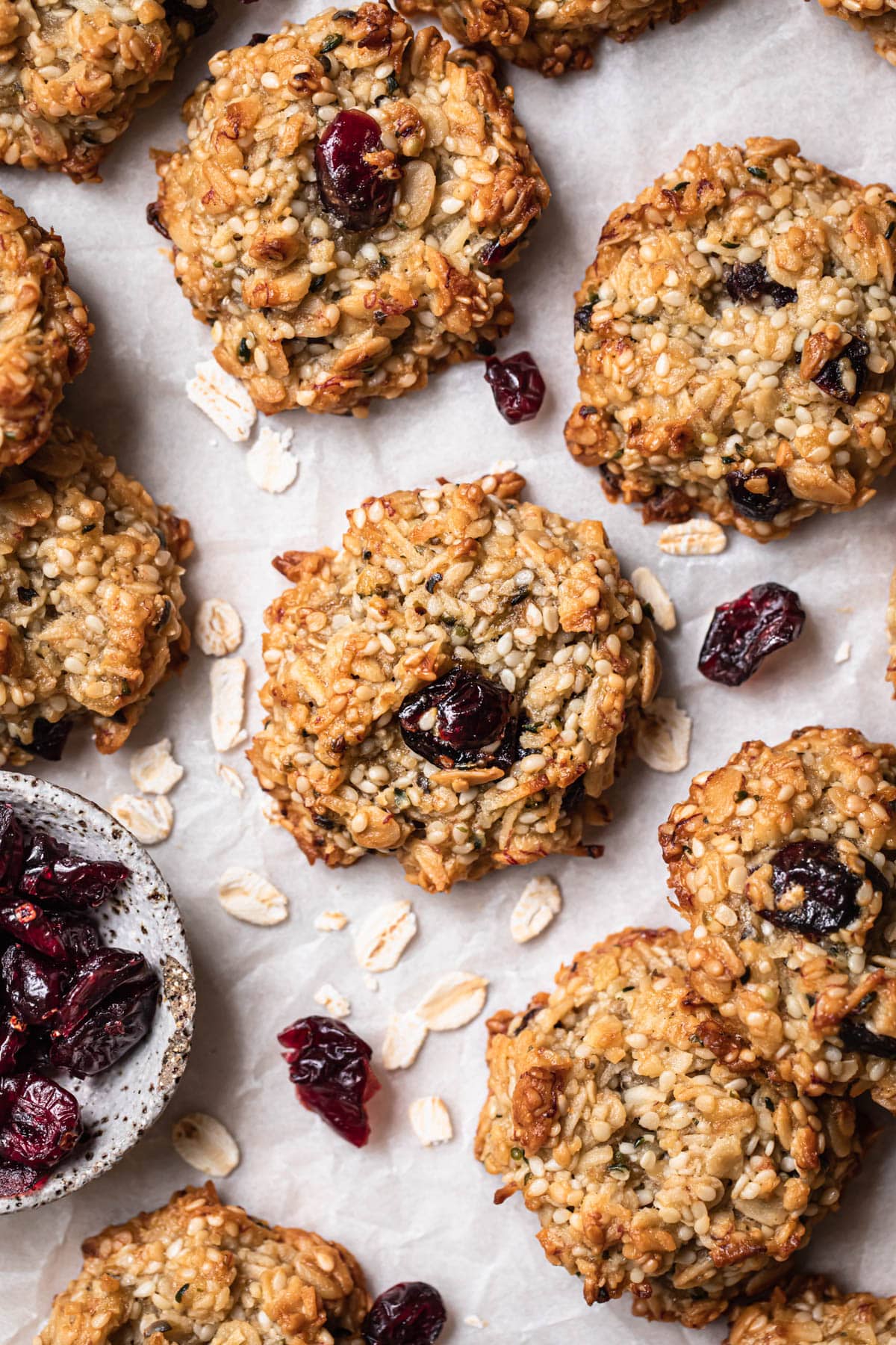 Healthy banana oat cookies on a board with dried cranberries in the background.