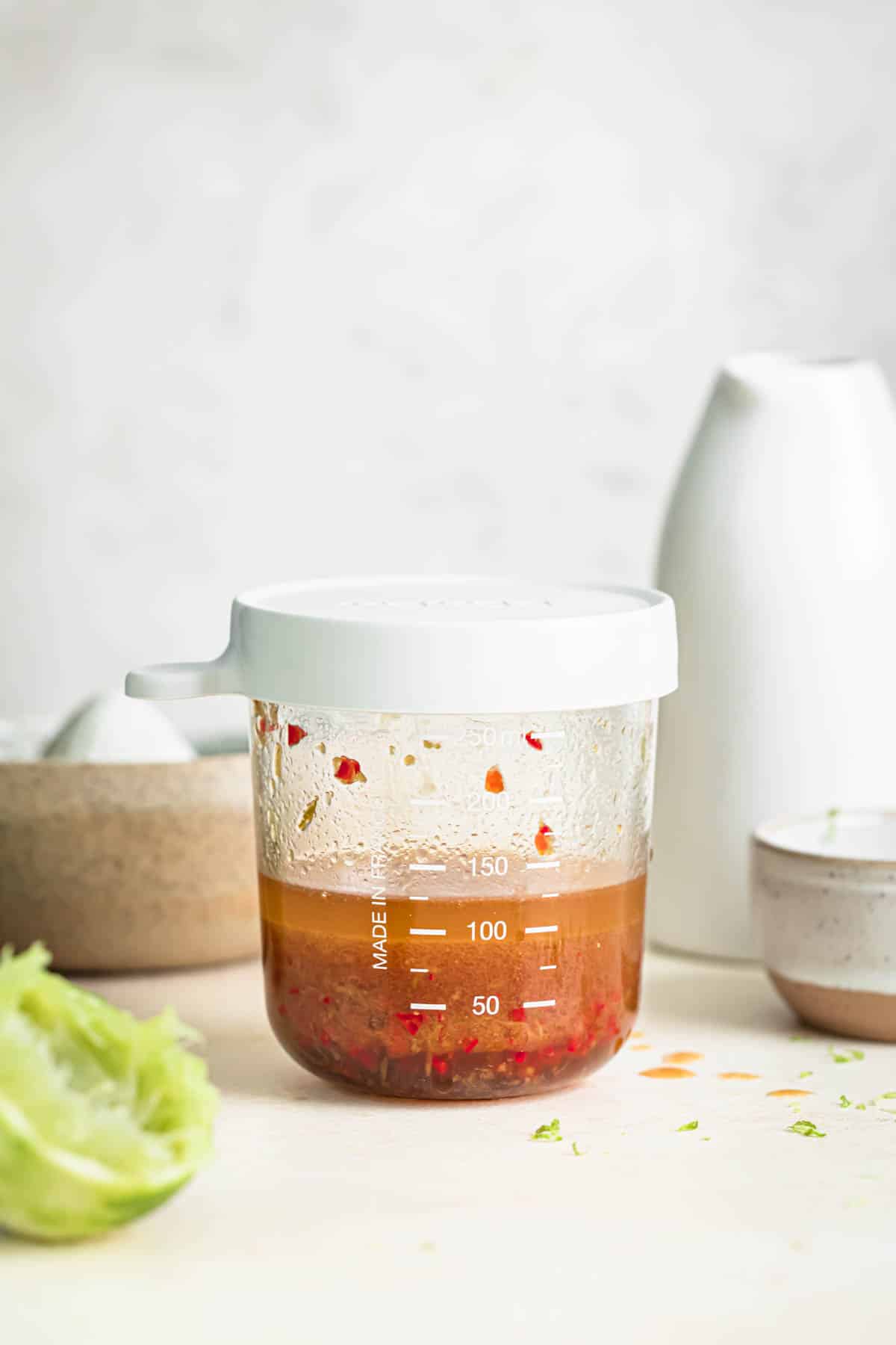 Chili lime dressing in a glass jar with an airtight silicon lid.