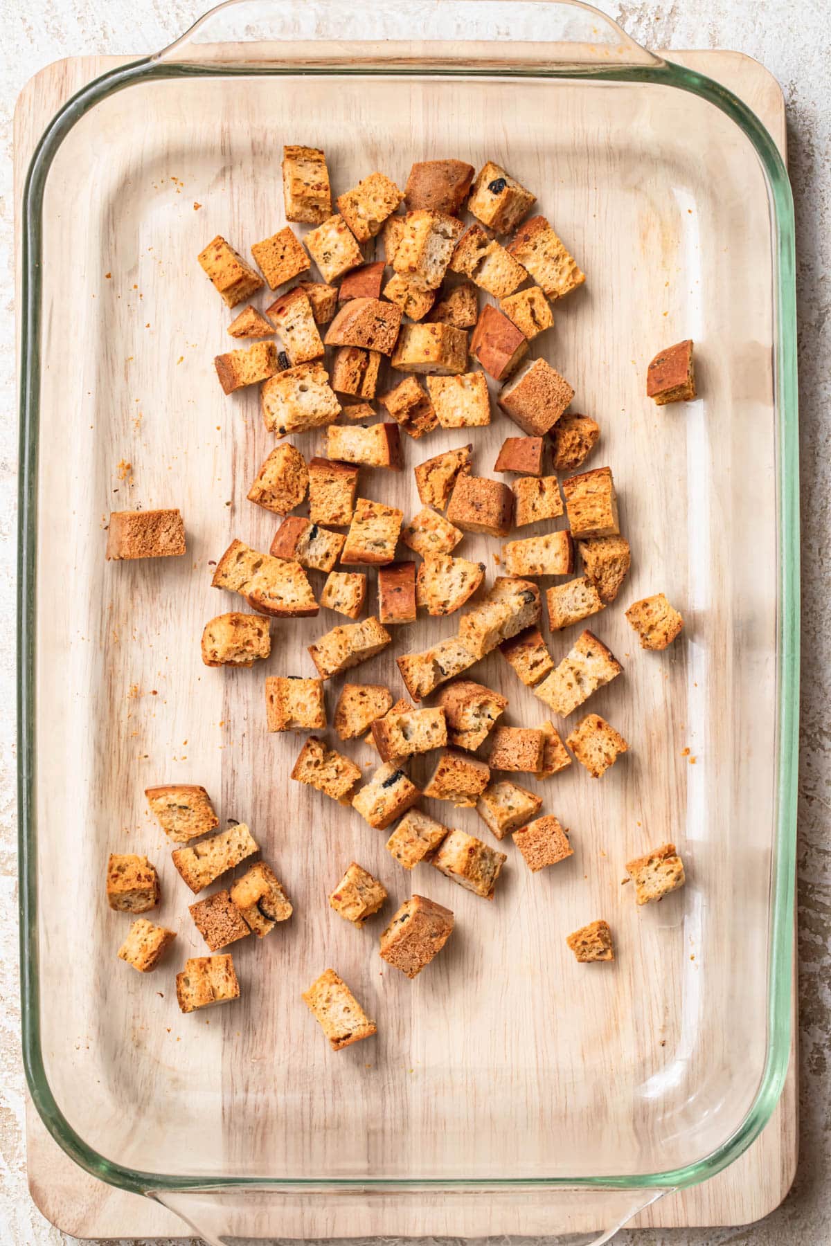 Golden toasted croutons in a glass baking dish.