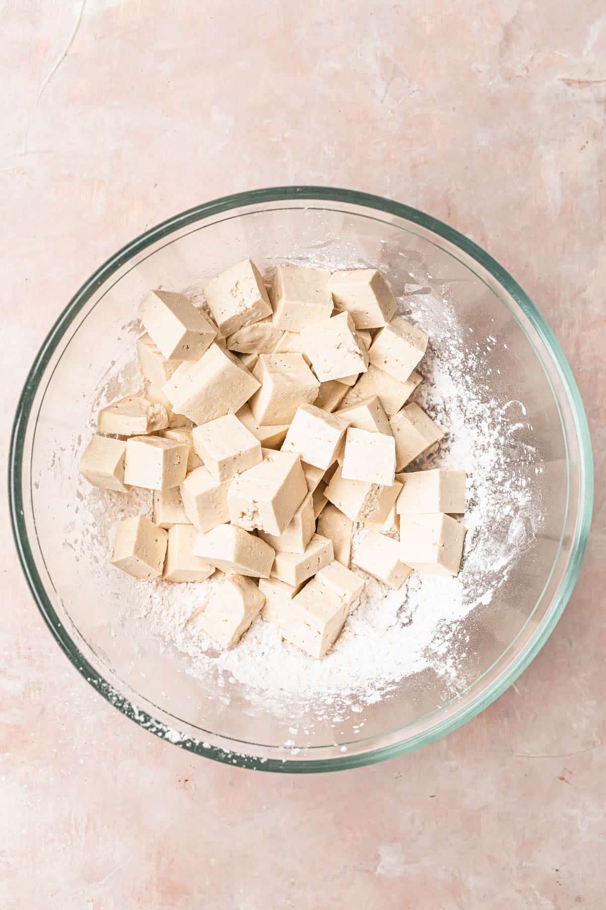 Tofu cubes added to a bowl of flour mixture.