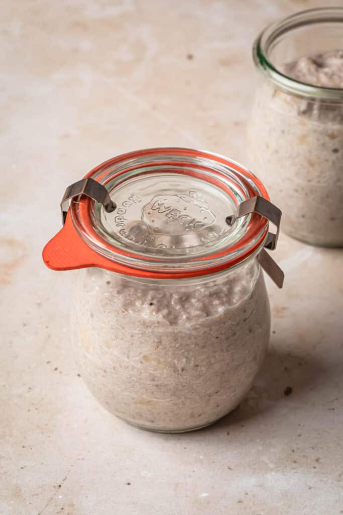 Banana chia pudding in a small glass Weck jar, with the lid secured firmly on.