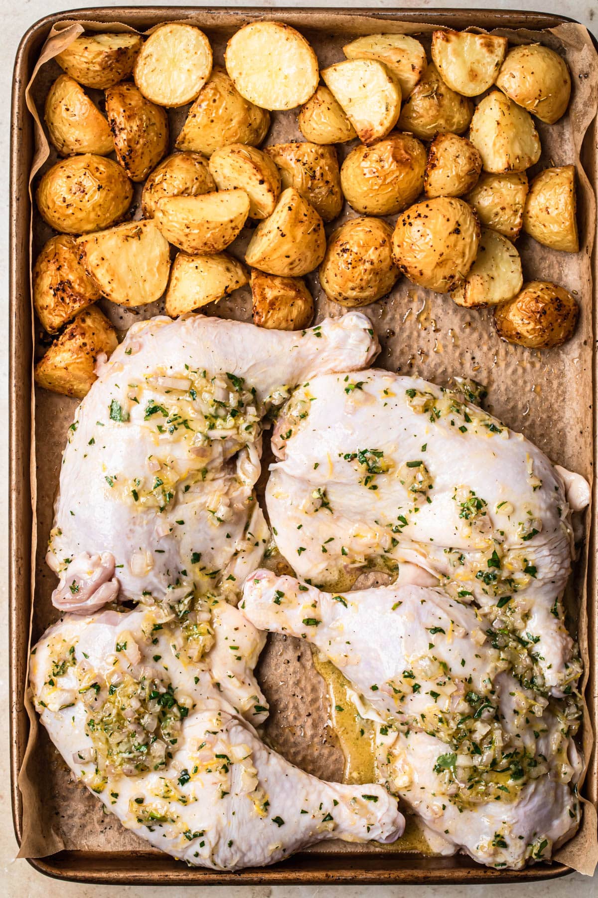 Marinated chicken Marylands added to the tray with baked potatoes.