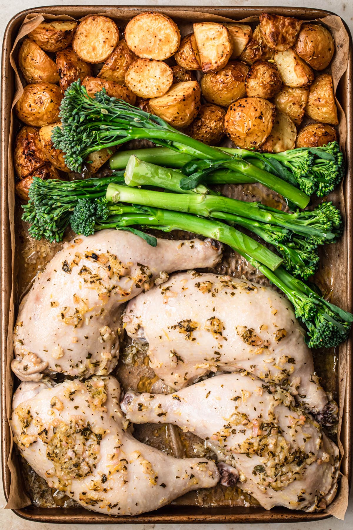 Marinated chicken, broccolini and roasted potatoes on a tray.