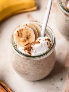 Banana chia pudding in a small Weck jar, topped with banana slices and a dollop of yogurt.