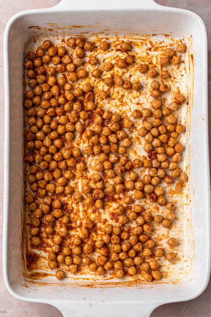 Seasoned chickpeas in a large white baking dish.