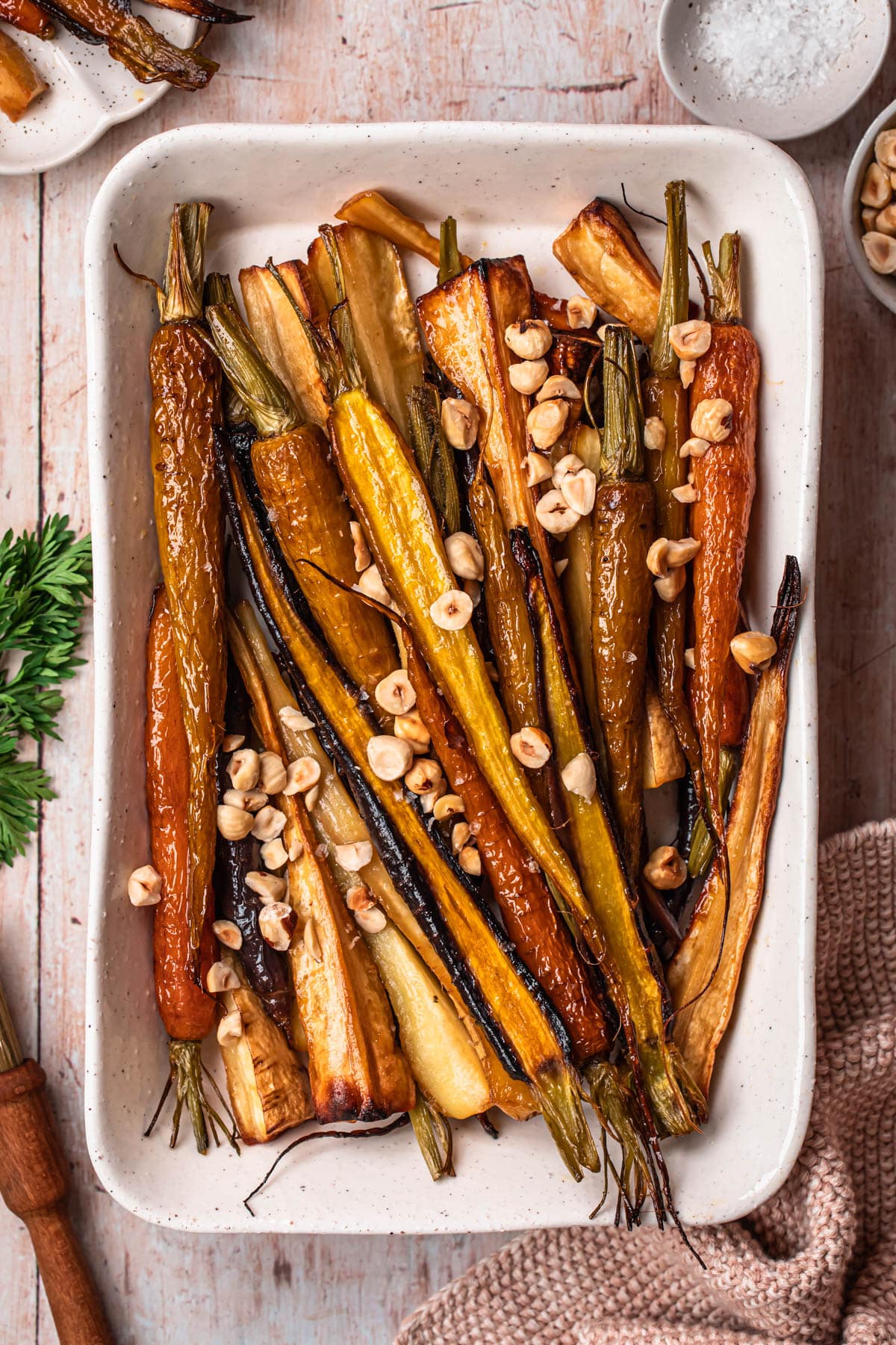 Honey roasted parsnips and carrots in a white serving dish.
