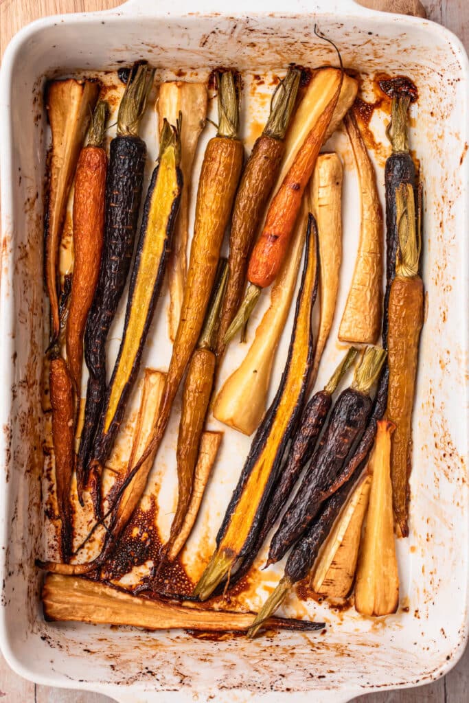Honey roasted parsnips and carrots in a large white baking dish.