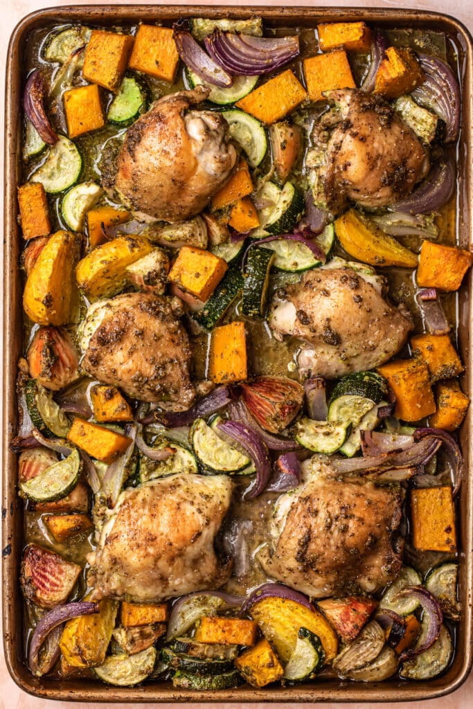 Pesto roasted vegetables and chicken on a large sheet pan.