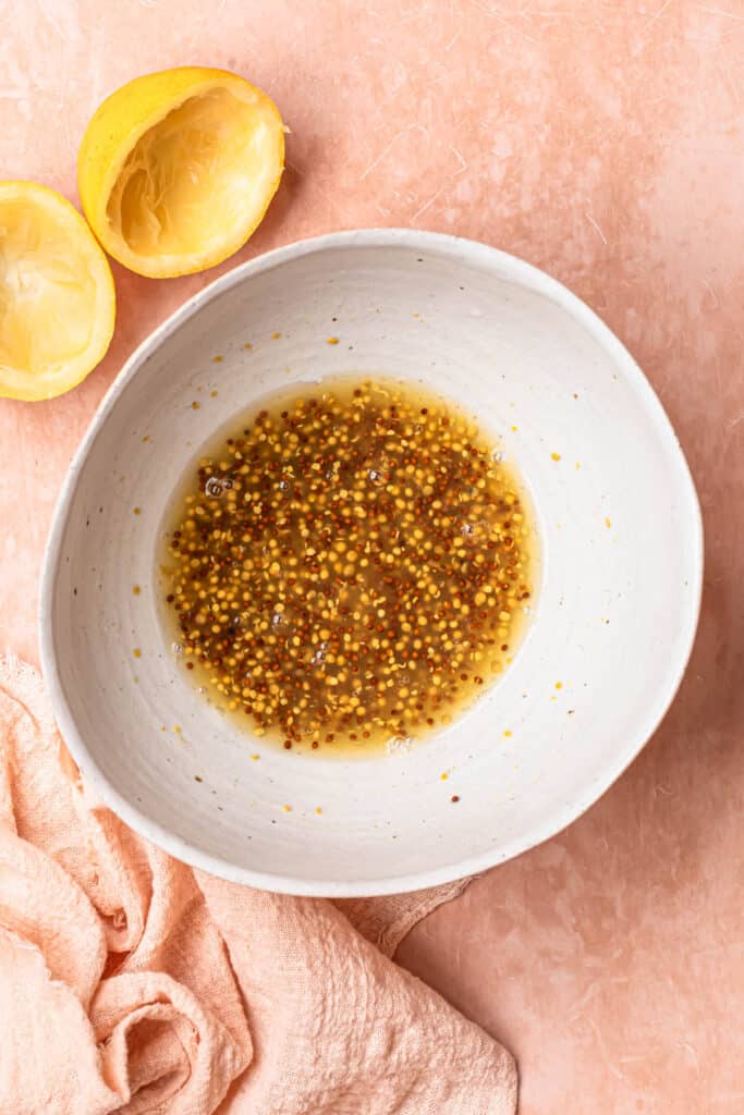 Wholegrain mustard, lemon juice, honey and salt mixed together in a small bowl.