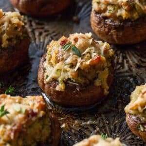 Close up of a tray of stuffed mushrooms topped with breadcrumbs cheese and herbs.