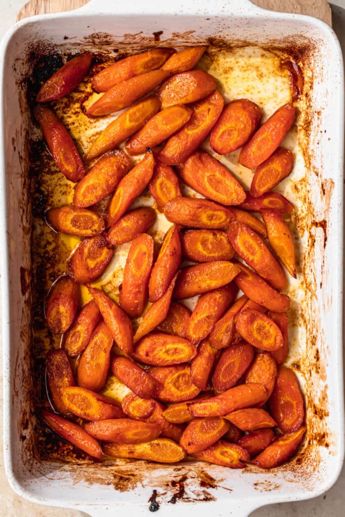 Carrots in a baking dish that have been roasted in honey, olive oil and spices.