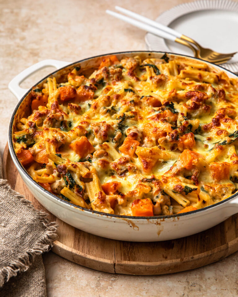 Butternut squash sausage pasta bake in a shallow casserole pan.