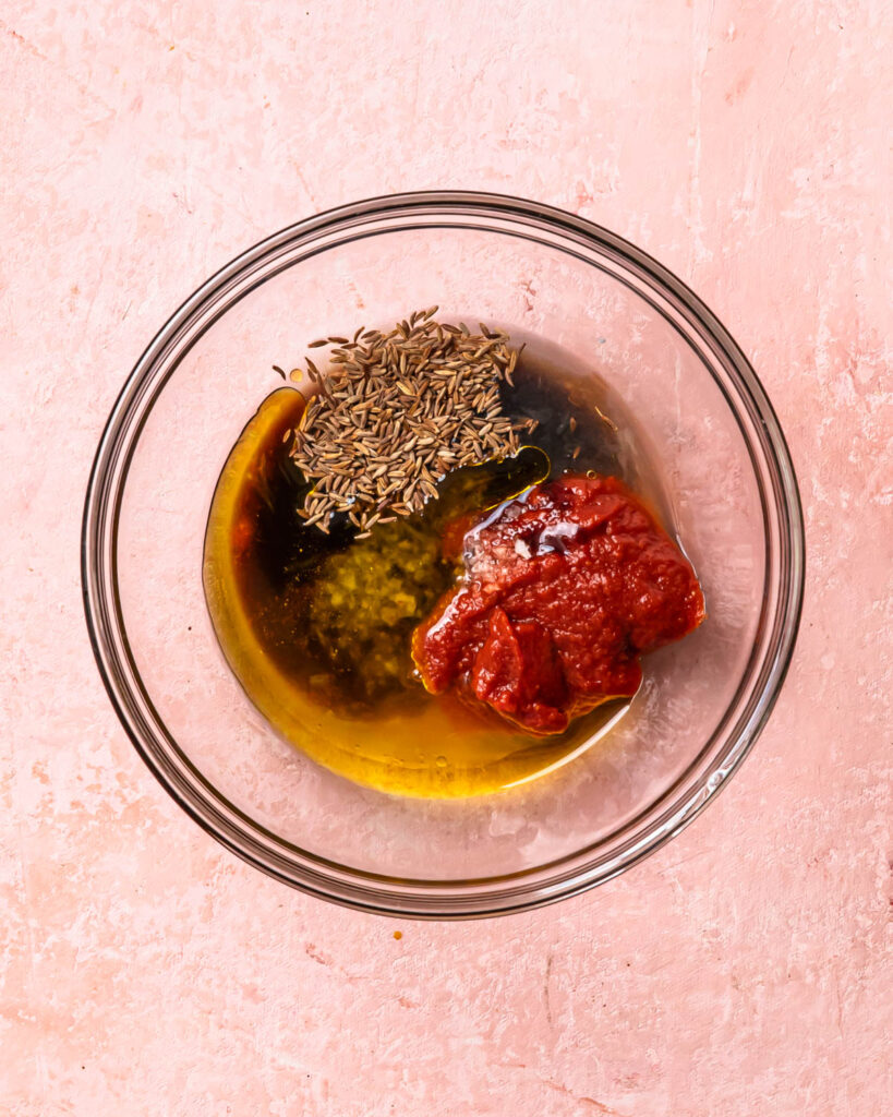 Ingredients for harissa marinade in a glass bowl. 