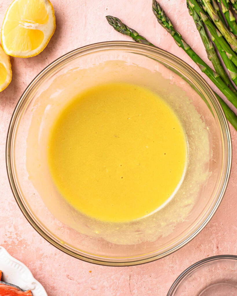 Lemon dijon marinade mixed together in a glass mixing bowl. 