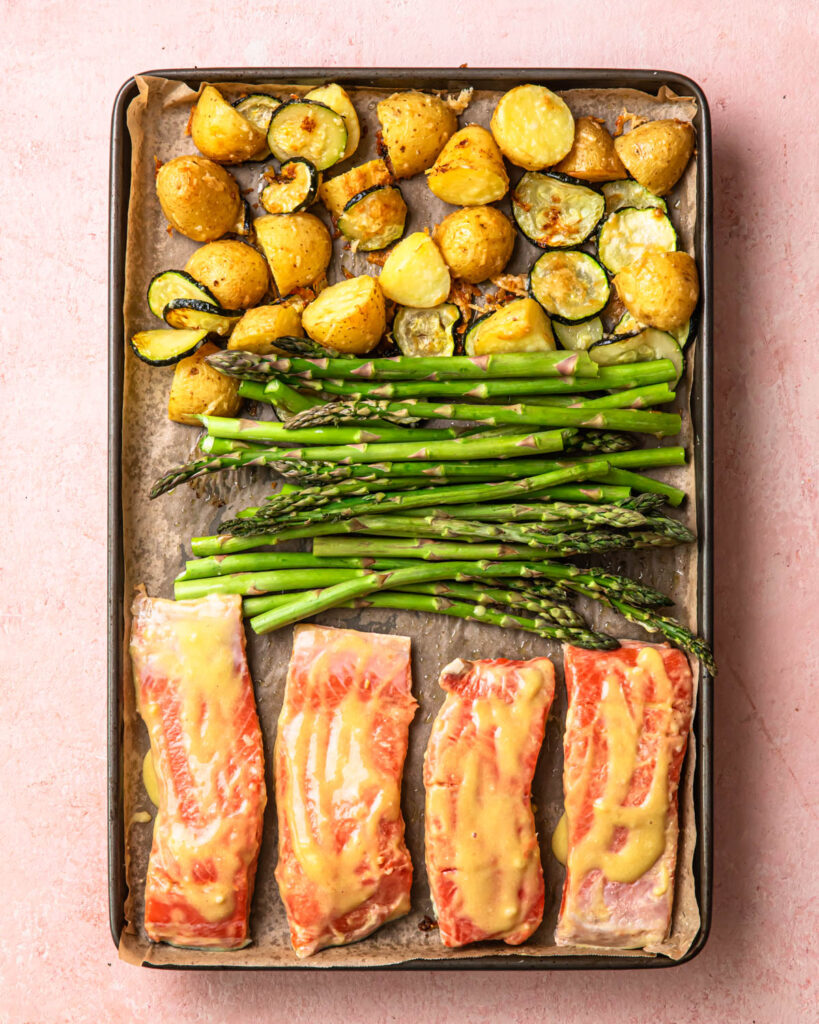 Sheet pan salmon and asparagus on a tray with roasted parmesan potatoes. 