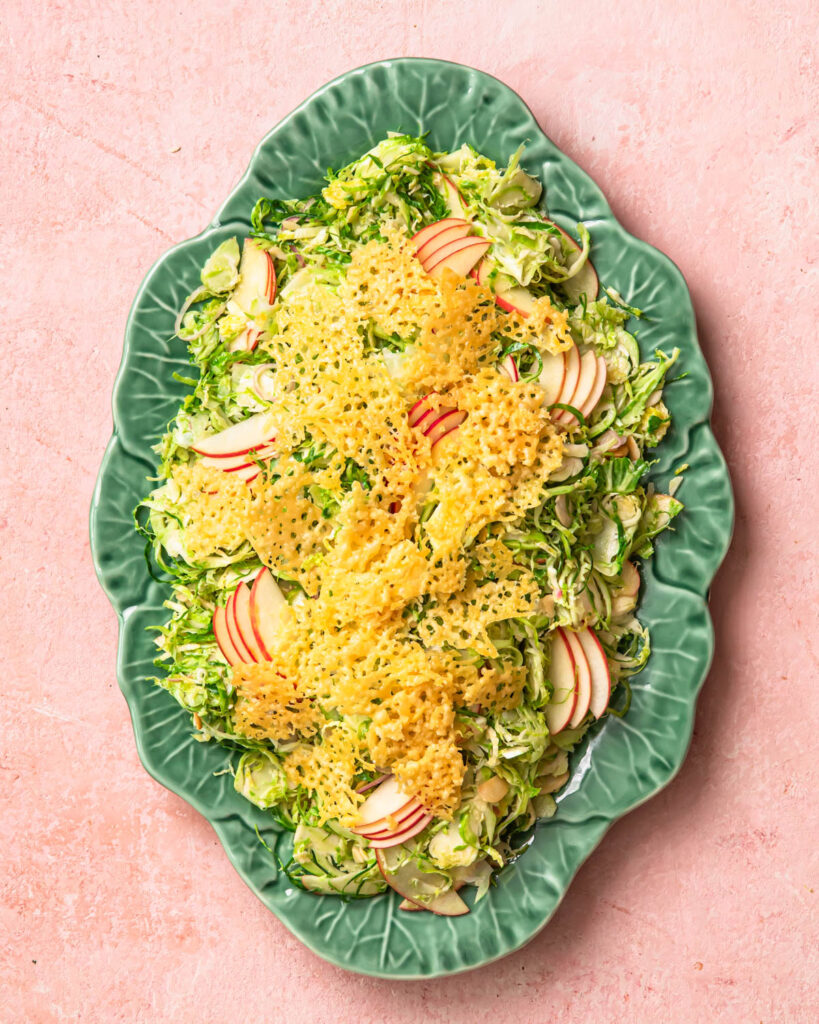 Shaved brussels sprout salad topped with parmesan crisps and apple slices.
