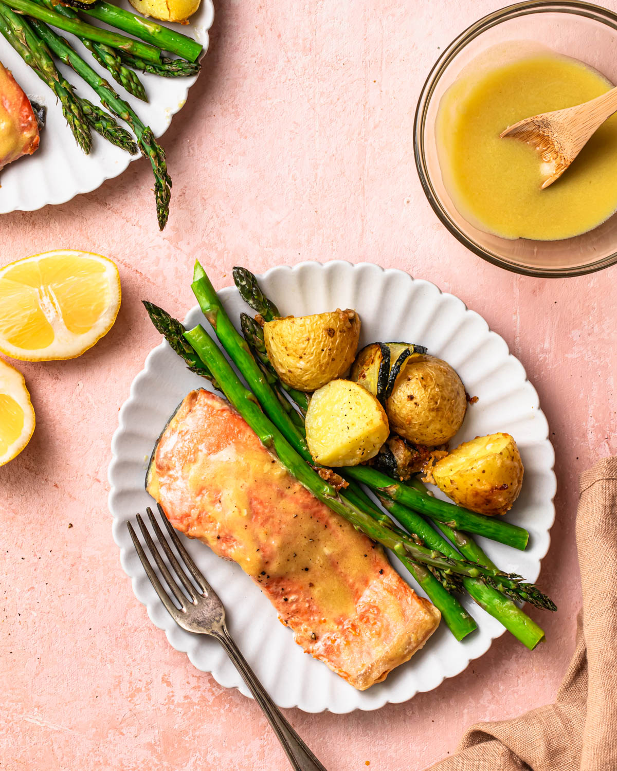 Marinaded sheet pan salmon and asparagus with parmesan roasted potatoes served on a plate.