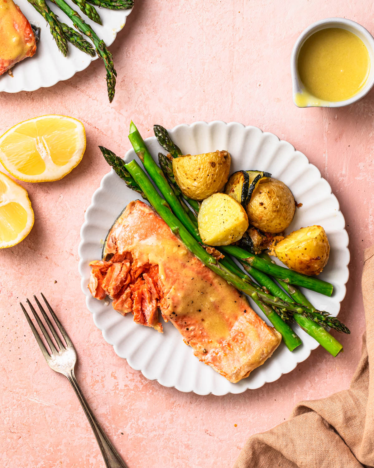 Marinaded sheet pan salmon and asparagus with parmesan roasted potatoes served on a plate.
