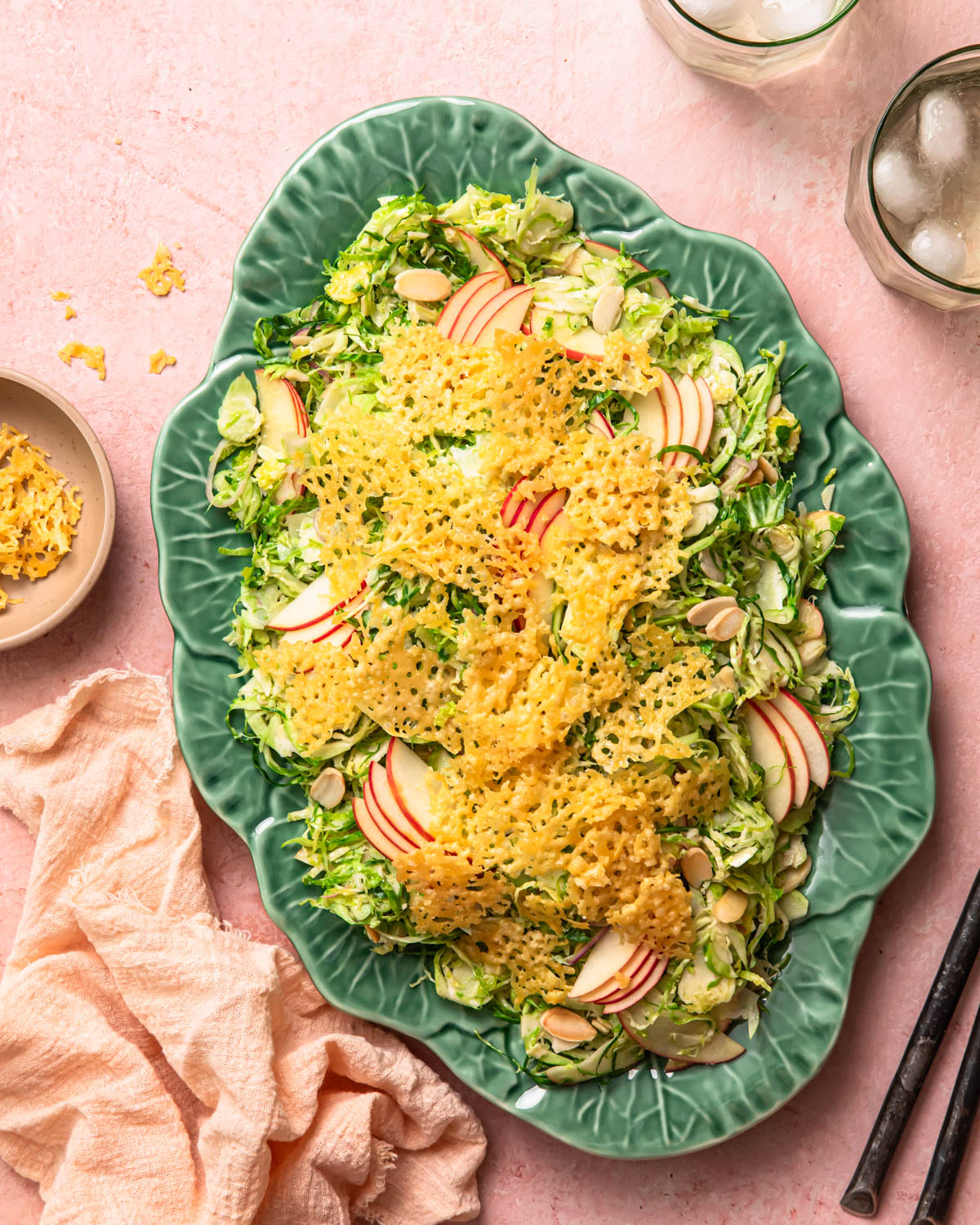 Shaved Brussels sprout salad topped with parmesan crisps on a serving platter.