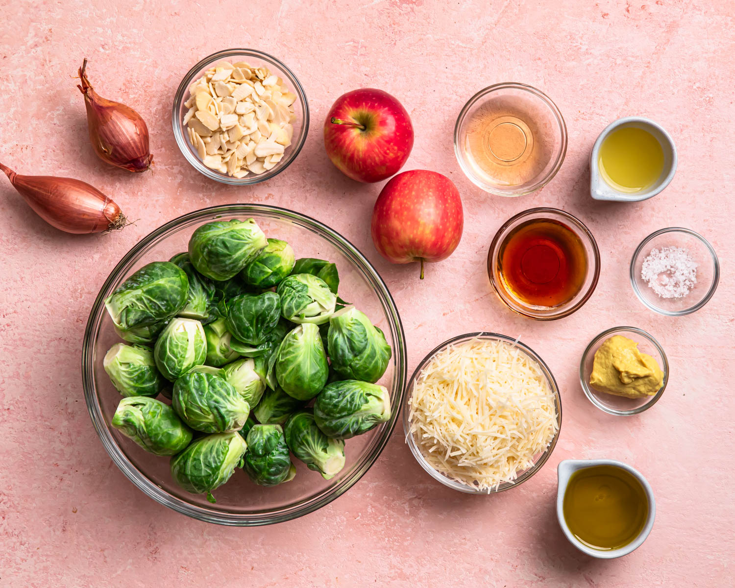Ingredients to make shaved Brussels sprout salad all laid out in individual bowls. 