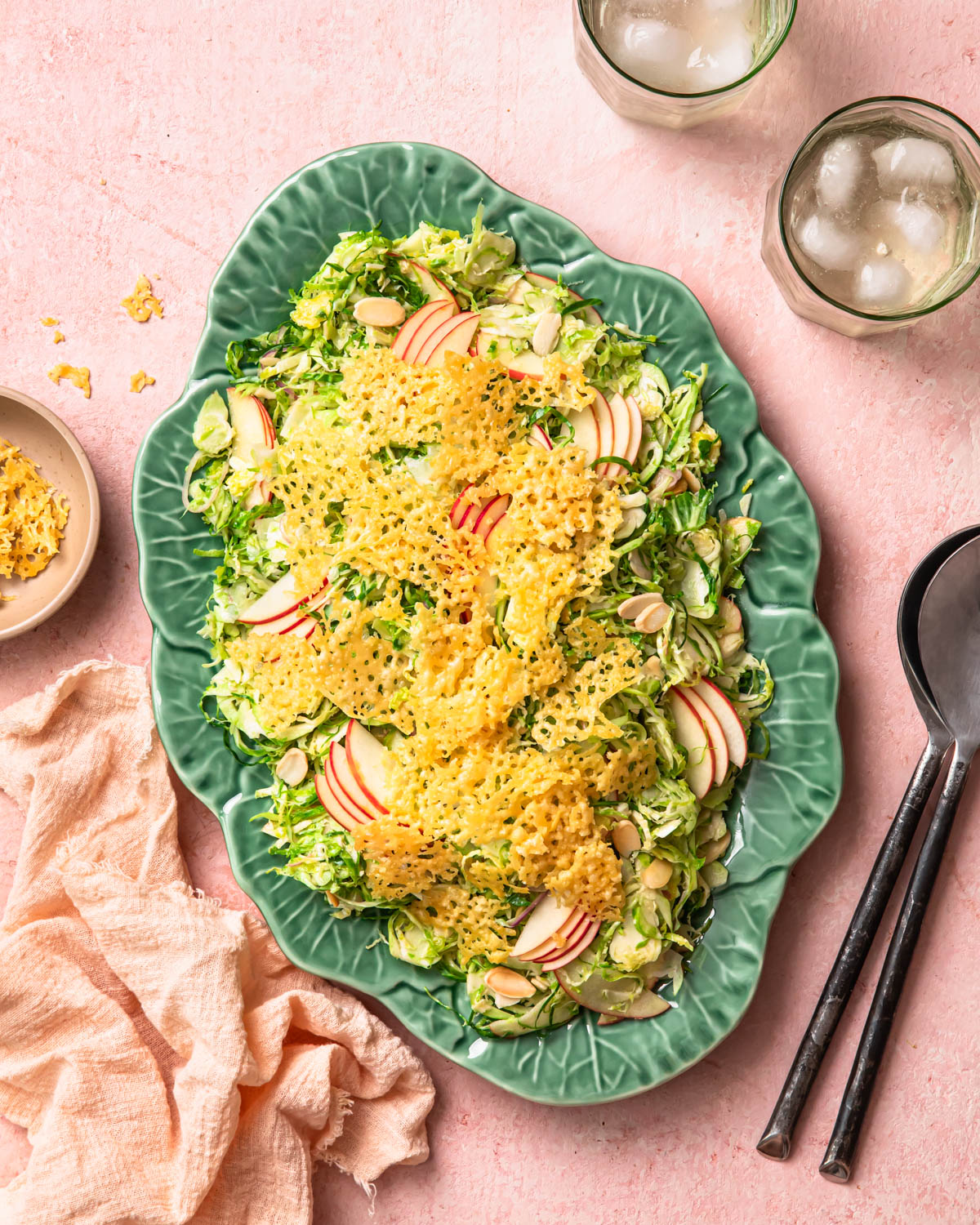 Shaved Brussels sprout salad topped with parmesan crisps on a serving platter.