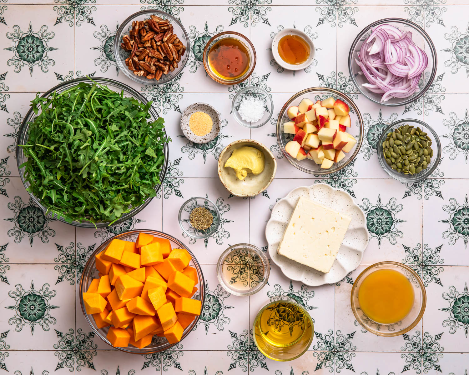 Ingredients for butternut squash and feta salad laid out in individual bowls. 