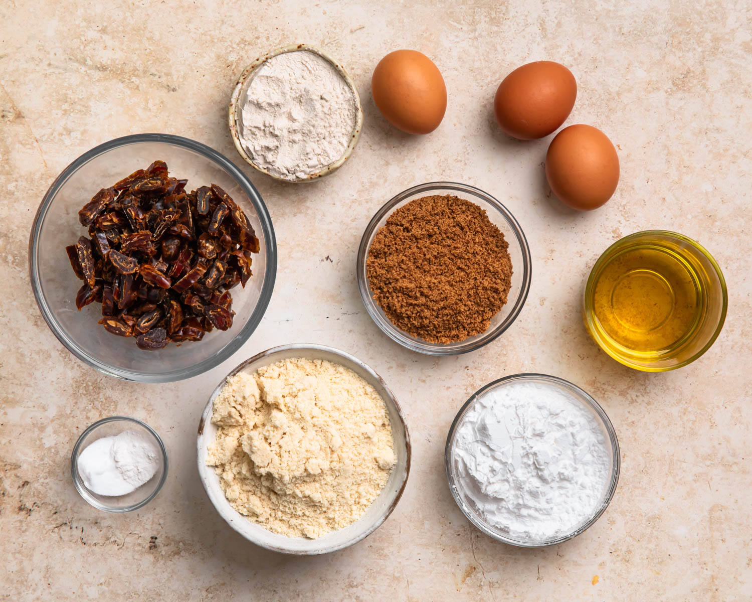 Ingredients for gluten free sticky date pudding laid out in individual bowls. 