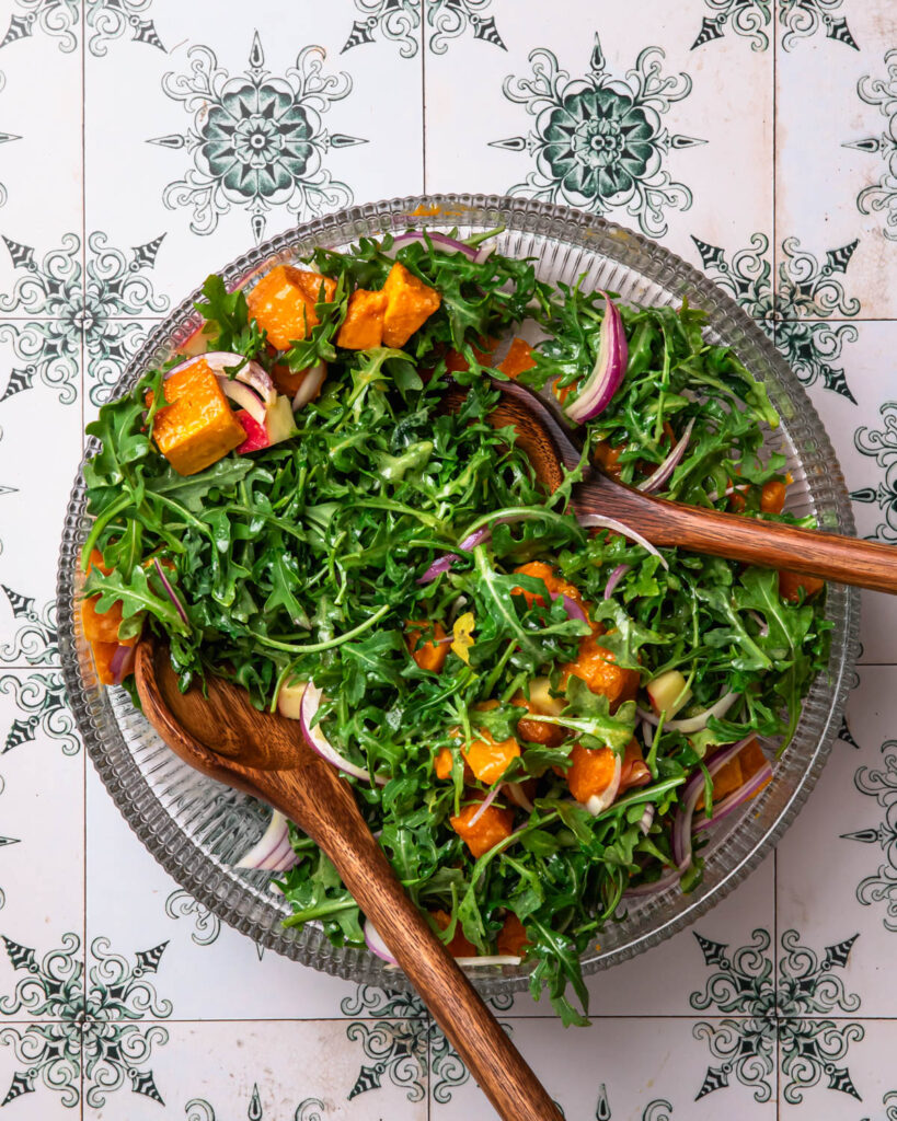 Butternut squash and feta salad tossed together in a salad bowl. 