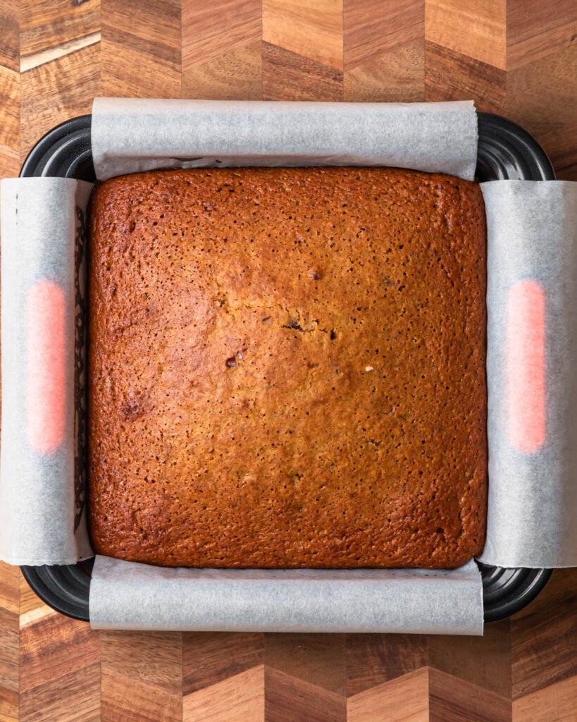 Baked sticky date pudding cake in a square baking tin.