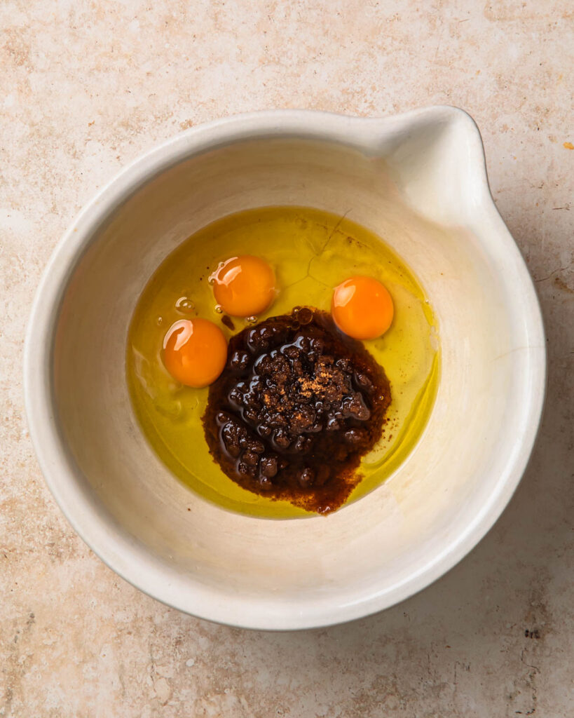 Wet ingredients for gluten-free sticky date pudding added to a bowl. 