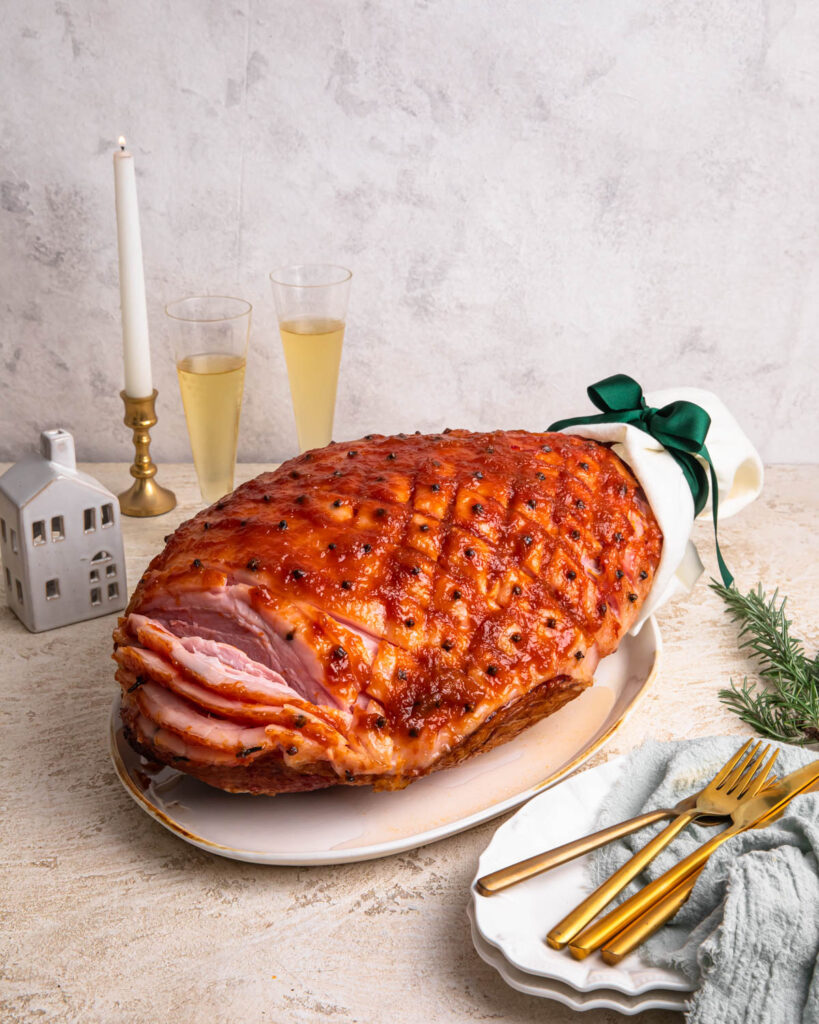 Spiced whiskey and apricot glazed ham on a serving platter.