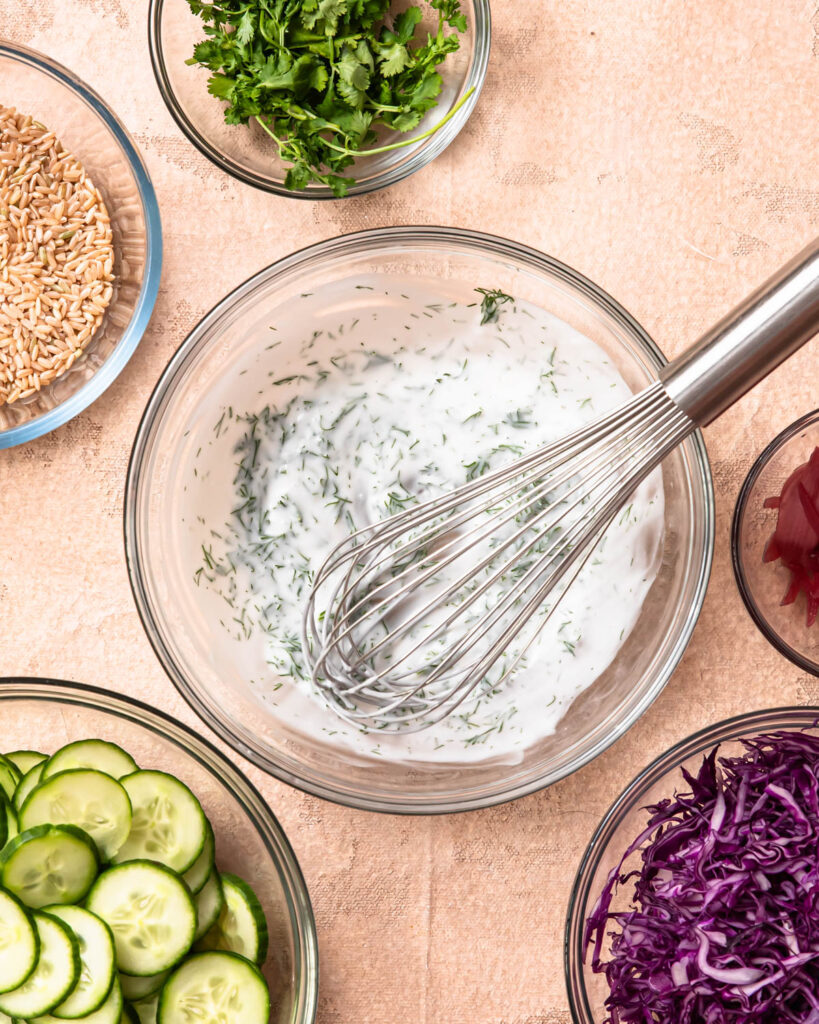 Creamy sauce for cucumber salad whisked together in a bowl. 