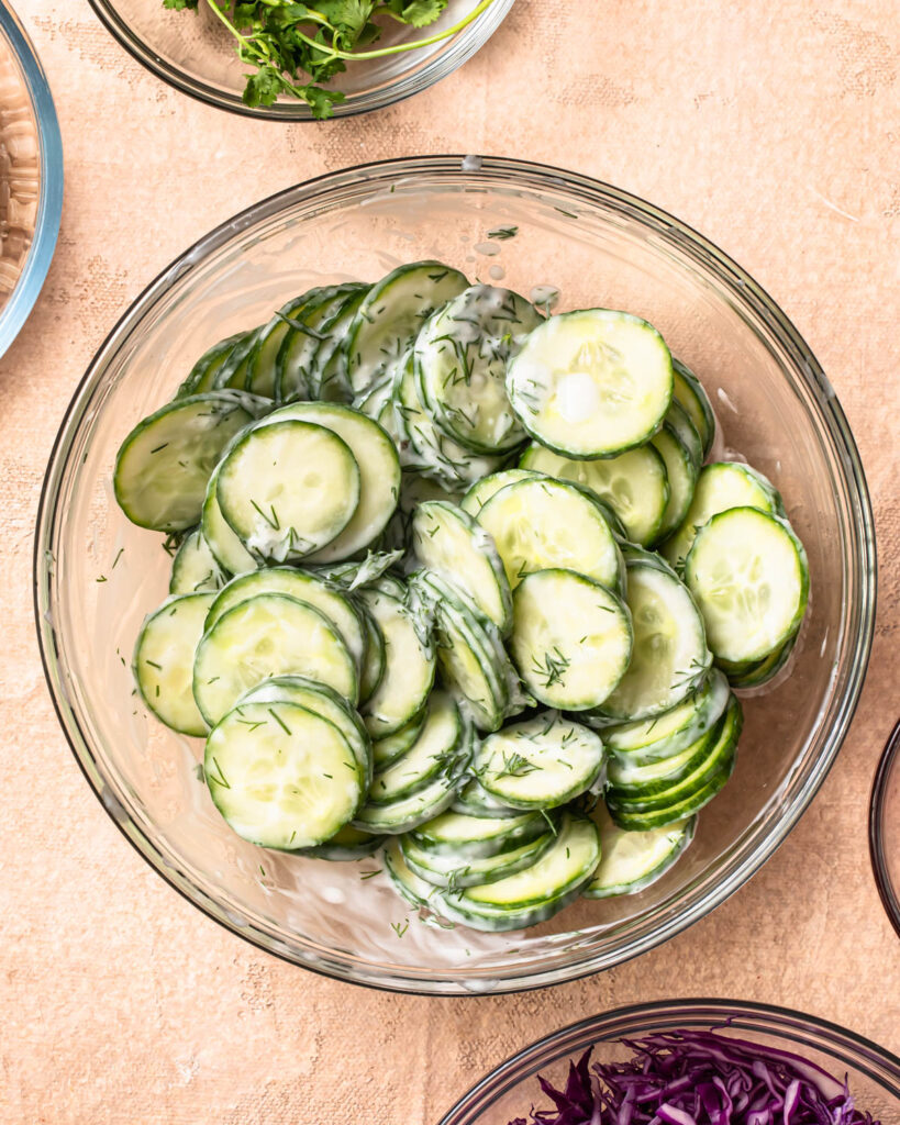 Creamy cucumber salad in a glass bowl. 