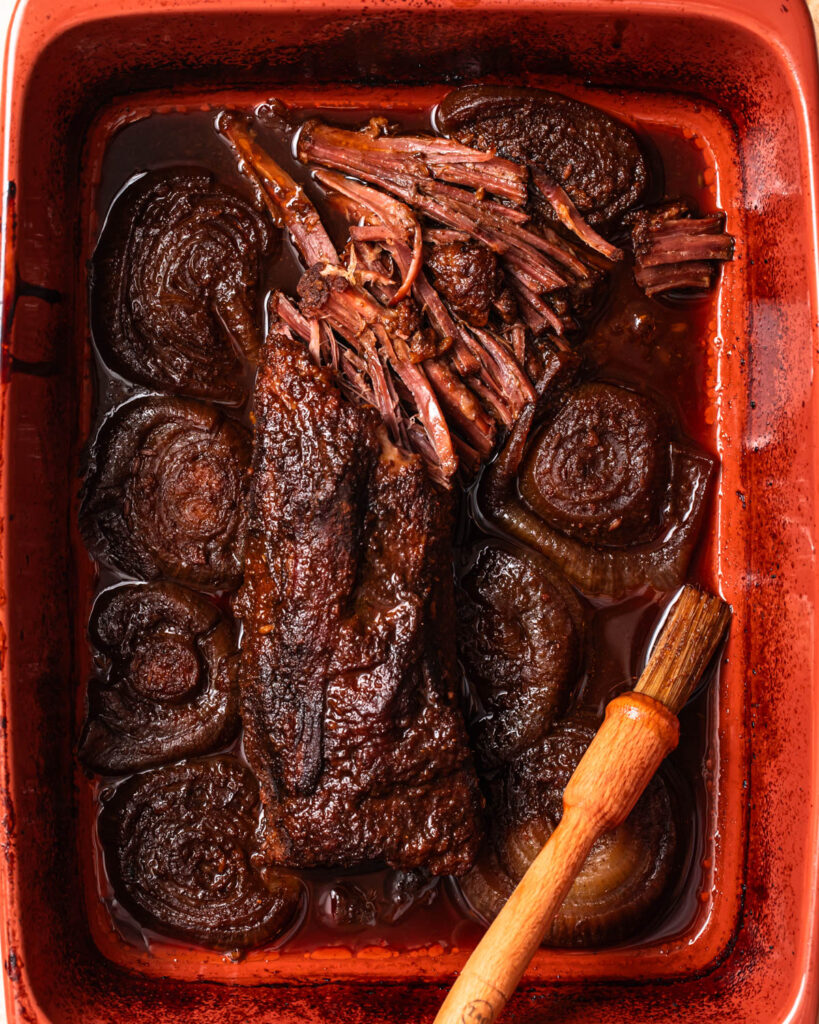 Cooked brisket in a baking dish.